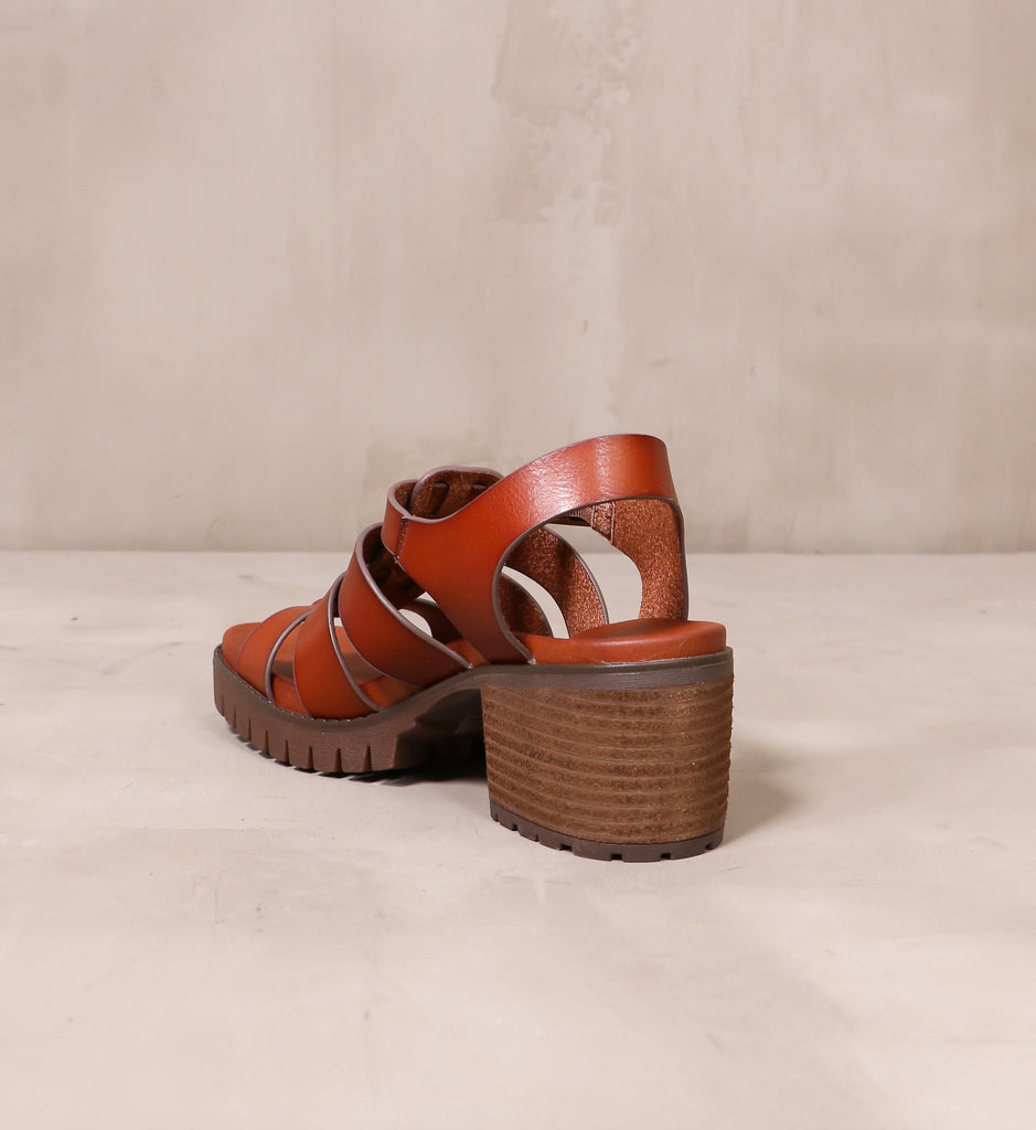 back of the stacked wood block heel on the brown leather strappy to cleat you sandal