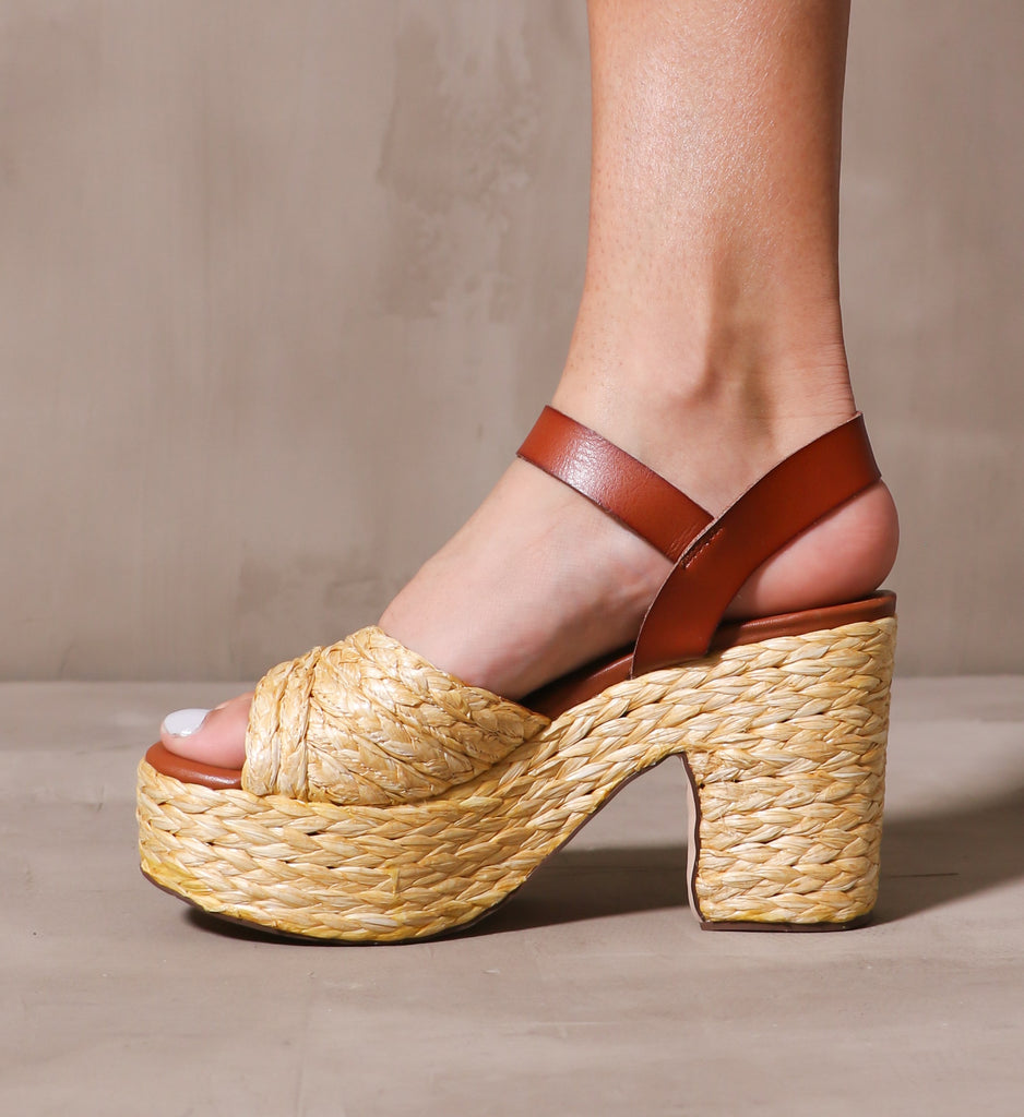 inner side of the straw attention platform sandal on model standing on cement background