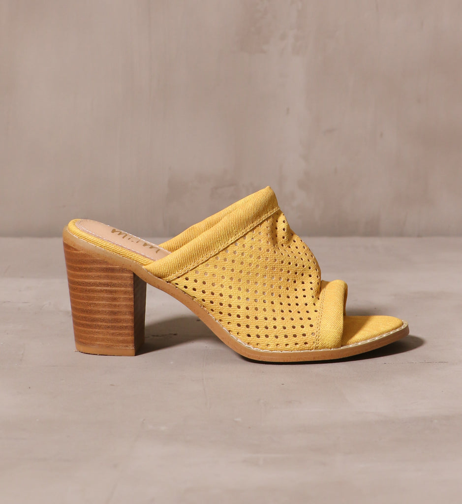 outer side of the yellow canvas sunshine state of mind heel with stacked wood block heel on cement background