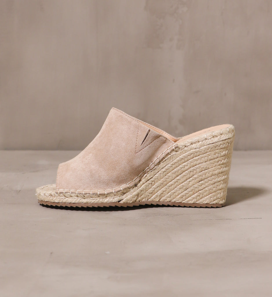 inner side of the talk to the sand with beige suede upper stitched on to the wedge sole with tan thread