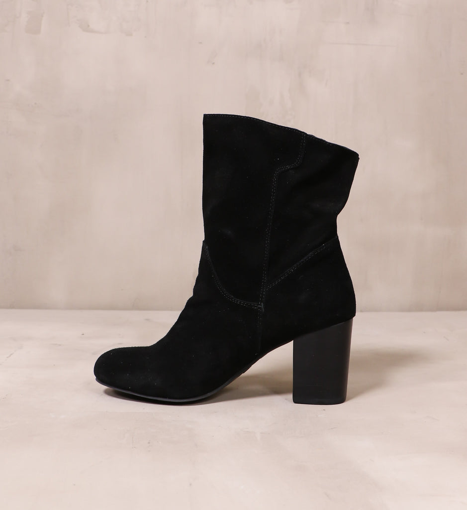 inner side of the all black thanks a scrunch block heel boot on cement background