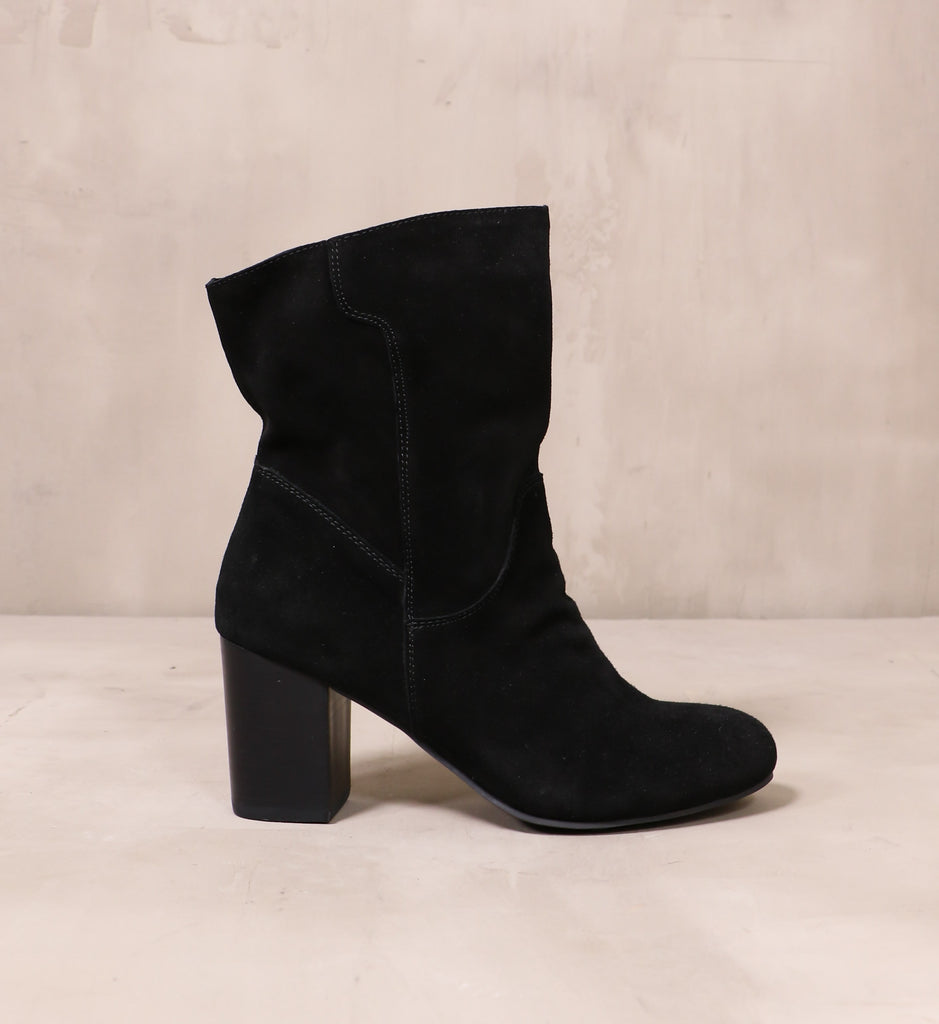 outer side of the all black thanks a scrunch suede leather boots with stacked wood block heel on cement background