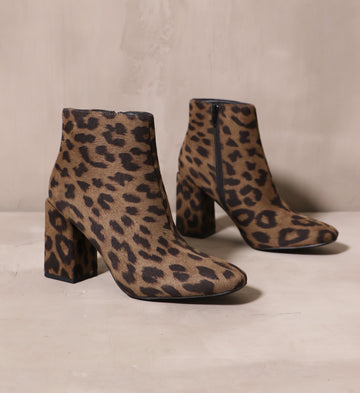 a pair of the cat's meow leopard print booties angled on cement background