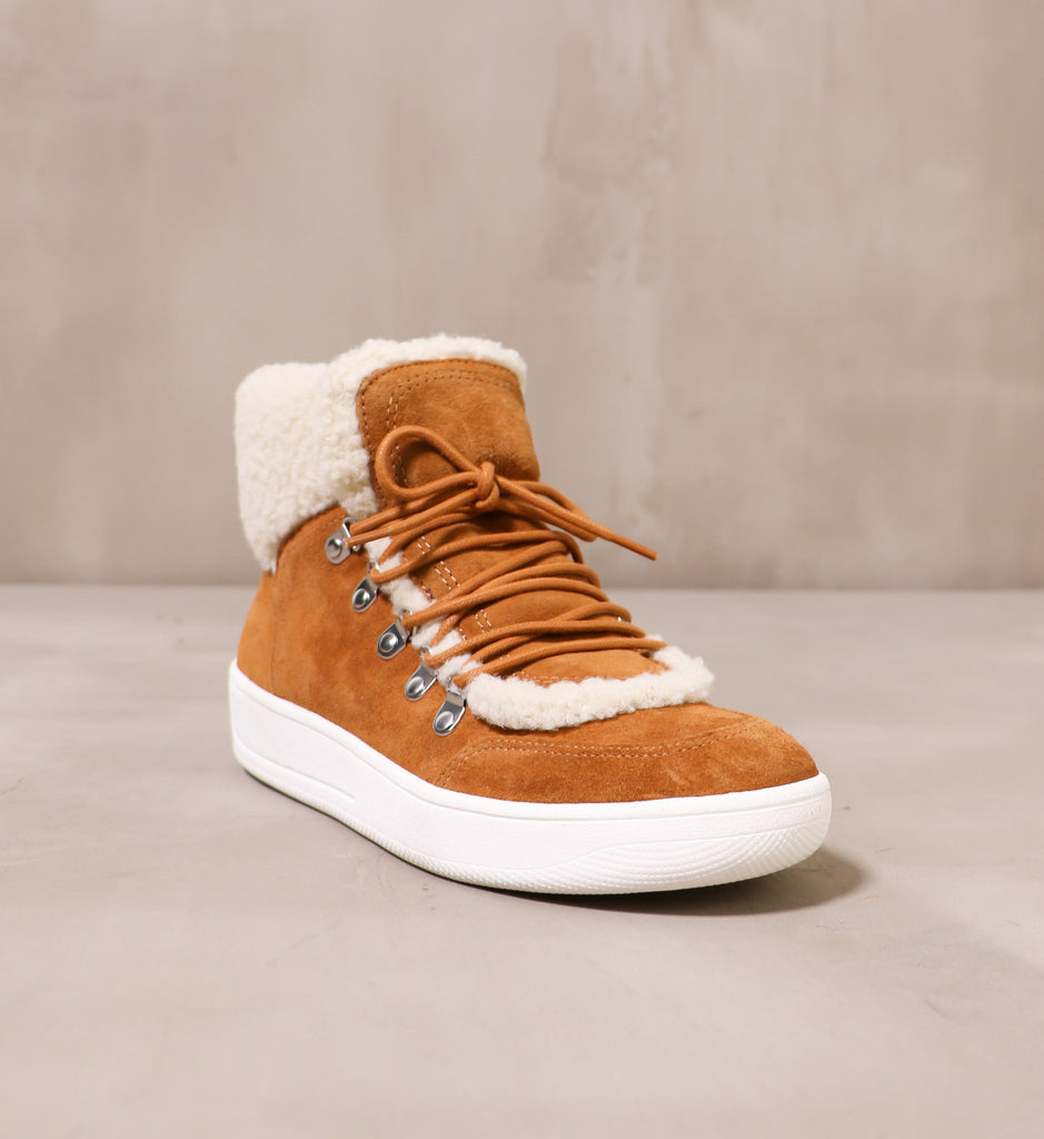 front of the lace up tan warming signs sneaker with cream fur trim