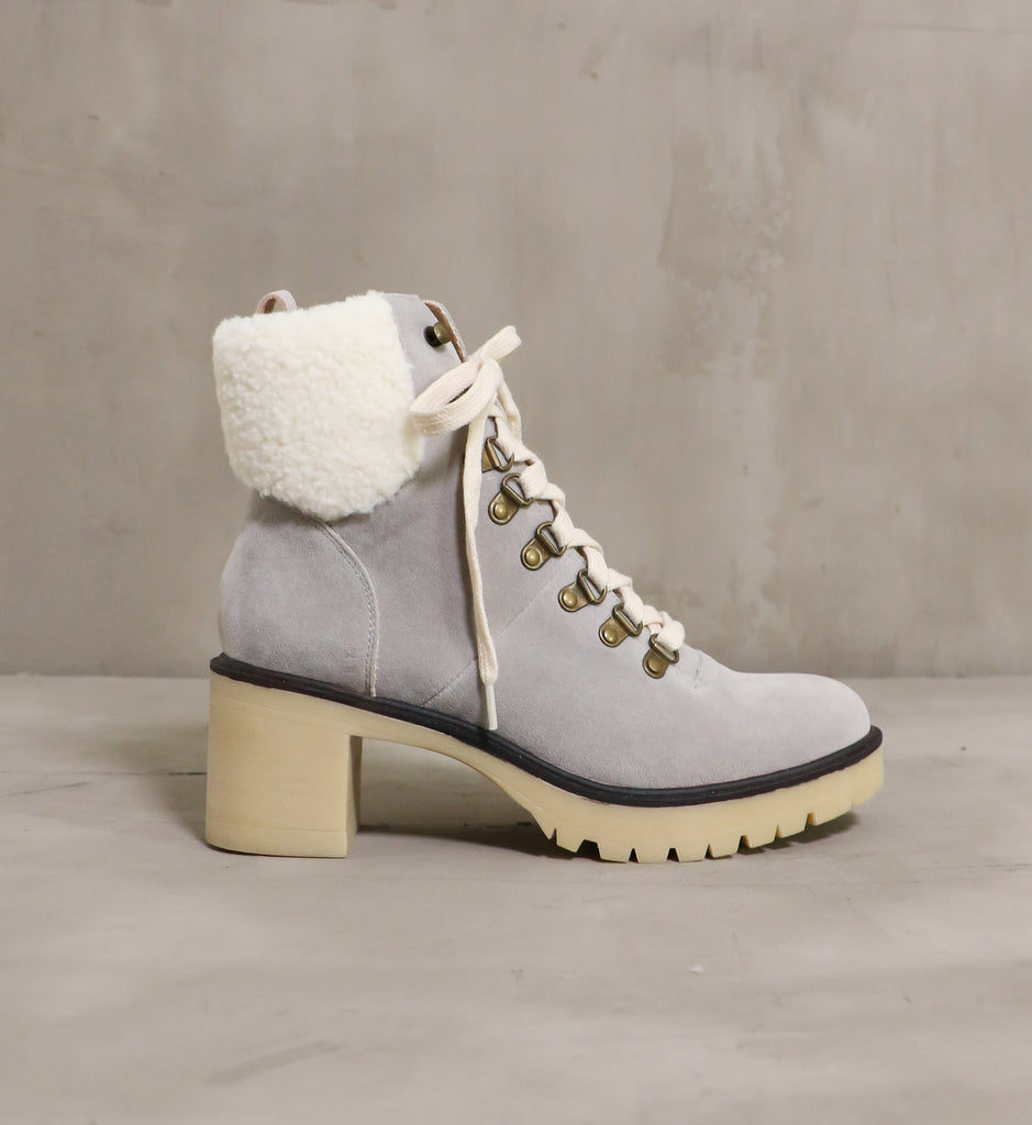 outer side of the warm sole boot on cement background with faux sherpa cream trim and chunky beige rubber lug sole