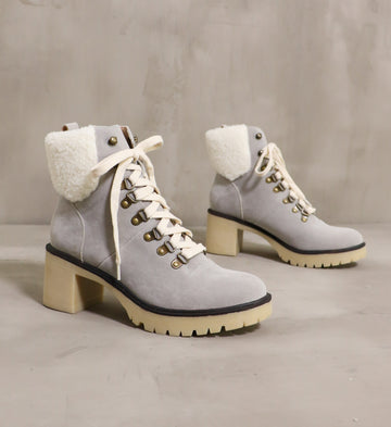 pair of grey suede warm sole boots angled on cement background