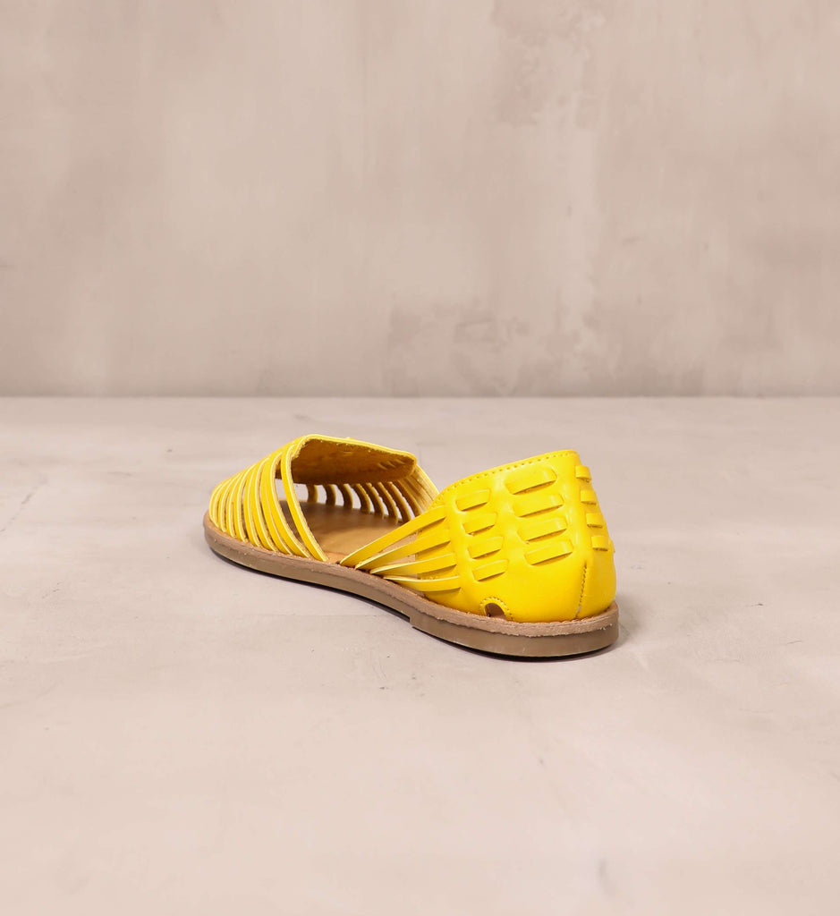 back of the yellow leather heel and brown sole of the weave it to me sandal