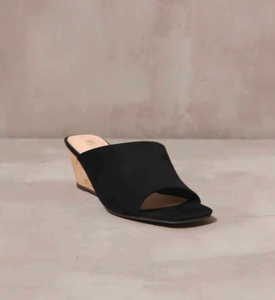 front of the open toe with square toe bed on the wedge of darkness black wedge sandal